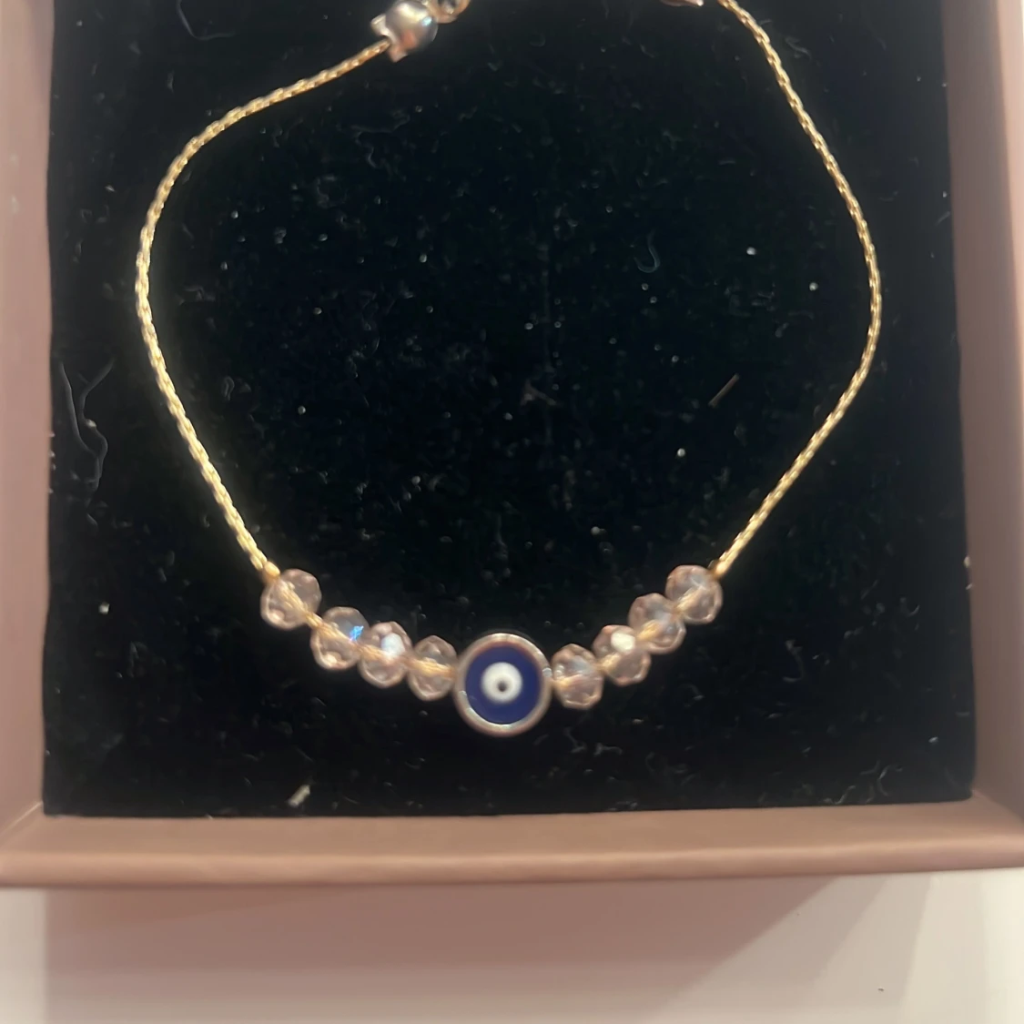 Guldigt armband med blått öga