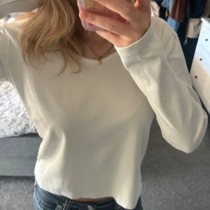 Tjockare långarmad från Brandy Melville - Enkel och stilren vit långärmad tröja från Brandy Melville. Tröjan är i lite tjockare och väldigt skönt material med rund halsringning och vågig kant. Perfekt till jeans eller kjol för en clean och chill look. Den är jättemysig. Kan behöva strykas innan användning om man inte hänger den rakt. Den har även två små fläckar på baksidan som knappt syns och tror de kom nu när jag tog bild tyvärr, så går nog bort i tvätten.