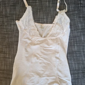 Vit spetslinnetopp från Twilfit - En jätte söt spetslinnetopp från twilift, hade för småa bröst för att kunna ha den här på, men sitter tajt på kroppen som XS. Hyfsat stretchigt material men toppen är INTE för småa bröst. Jag skulle säga från C kupp och uppåt i bröststorlek. (Jag har 75B)