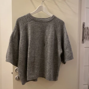 Grå stickad tröja med korta ärmar  - Tröjan är ifrån lager 157 och är bara använd 2-4 gånger, inga tecken på användning 