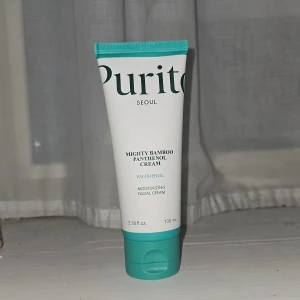 Purito Mighty Bamboo Panthenol Cream - Nästan allt kvar! Fuktgivande ansiktskräm från Purito med panthenol och bambu. Tuben är vit med turkos lock och detaljer, innehåller 100 ml. Vegansk och tillverkad i Korea, perfekt för dig som vill boosta din hud med extra återfuktning och mjukhet.