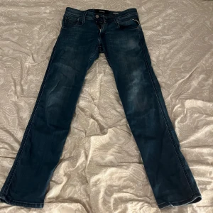 Replay Anbass slim fit jeans blå - Snygga blå Replay Anbass jeans i slim fit med klassisk femficksdesign och diskreta slitningar. Jeansen har raka ben och är tillverkade i mjukt denimtyg som sitter skönt hela dagen. Perfekta för dig som gillar en stilren och modern look. Nypris 1200, mitt pris 450! 8/10 skick.