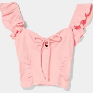 Rosa top från bershka - Supersöt ljusrosa croppad topp med volangärmar och knytning framtill. Från bershka