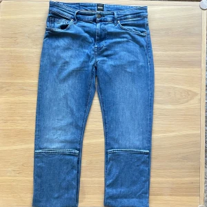 Blå jeans från BOSS. Regular fit.  - Snygga blå jeans från BOSS med klassisk femficksdesign och raka ben. Jeansen har en snygg metall BOSS-logga på Myntfickan. Tillverkade i mjukt denimtyg som sitter skönt hela dagen. Nästan som kashmir! Originalpriset: 1000kr. Mitt pris: 250kr!!