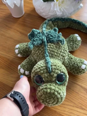 Stor olivgrön drake🐉💚 - Här har jag virkat en stoooor olivgrön drake med mörkgröna detaljer och ögon💚🐉 Den är större än dom andra drakarna🐉 Den är gjord på mjukt garn från Rusta och har hårda gröna ögon som inte går att ta av💚 den är stoppad med mjukstoppning🐉🥰 älskar att virka och hoppas denna gör någon glad🥰Den är 60 cm om man sträcker ut svansen💚💚