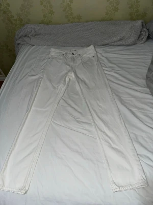 Vita jeansbyxor från C Jeans, regular - Snygga vita jeansbyxor från C Jeans i regular fit. Klassisk femficksmodell med silverfärgade nitar och knapp. Byxorna är raka i modellen och har en stilren look som passar till det mesta. Materialet är jeans i bomull för en skön känsla.