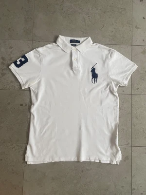 Ralph Lauren Polo Vit - Big Pony - Hej! Säljer nu min vita Ralph Lauren polo eftersom att den inte används så mycket längre. Har används sparsamt i några månader under sommaren! || Skick: 8.2/10 || Storlek: L, Slim Fit || Tveka inte på att höra av dig vid frågor, funderingar eller prisförslag🙌