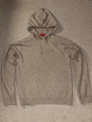 Grå hoodie från RYVLS med huva - Mysig beige stickad hoodie från RYVLS. Perfekt för chill dagar eller när du vill ha något enkelt och bekvämt. 