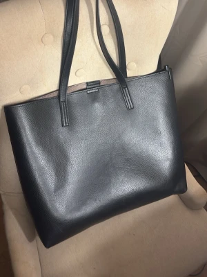 En stor svart axelväska  - En stor axelväska som är praktisk och har plats för mycket , den är använd cirka 2 gånger. Den har mycket plats plus en liten ficka inne 