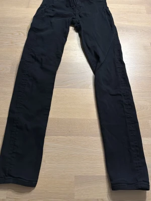 Svarta slim byxor J.Lindeberg Grete - Säljer ett par svarta byxor från J.Lindeberg, modell Grete. De har slim fit och rak passform, tillverkade i mjukt bomullsmaterial. Klassisk design med dragkedja och knapp framtill. Perfekta till en clean och stilren look.