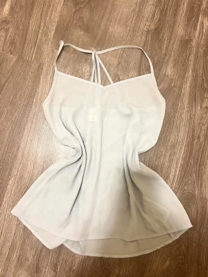 Ljusblå linnetopp Abercrombie & Fitch - Säljer en ljusblå linnetopp från Abercrombie & Fitch i storlek XS. Toppen har tunna axelband och en lätt v-ringad halsringning. Materialet är tunt och svalt, perfekt för varma dagar. Enkel och stilren design som passar till mycket.
