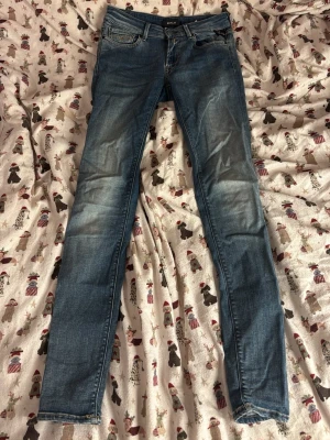 Replay skinny jeans blå, storlek 24 - Säljer ett par blå Replay jeans i modellen Luz. De har skinny passform, klassisk femficksdesign och snygga slitningar framtill. Jeansen har normal midja och är tillverkade i mjukt jeansmaterial med stretch för extra komfort.