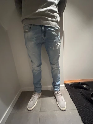 Ljusblå slim fit jeans från diesel - Säljer ett par ljusblå Levis jeans i slim fit med slitningar och distressed detaljer på låren och knäna. Klassisk femficksmodell med diesel-logga på bakfickan. Jeansen är gjorda i mjukt denimtyg som sitter tajt längs benen. Inköpspris 3800, modellen är 184, tveka inte på att höra av er vid frågor! Pris kan diskuteras vid snabb affär😀