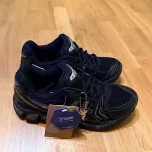 Skor - Säljer ett par Asics Gel Kayano i svart. Skorna är i nyskick och har använts vid tre tillfällen. De är i storlek 43,5 och erbjuder den klassiska komfort och stabilitet som Gel Kayano-serien är känd för, vilket gör dem perfekta både för löpning och vardagligt bruk.  Ett utmärkt val för dig som vill ha en stilren och högkvalitativ sko med bra stöd och dämpning. Vid snabb affär finns möjlighet till prisjustering och du är varmt välkommen att ställa frågor! 1: