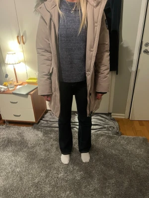 Beige dunjacka med fuskpäls - Snygg beige kappa från sebago med huva och fuskpälsdetalj. Lång modell med dragkedja framtill och fickor på sidorna. Perfekt för kalla dagar och har en klassisk, stilren look. Passar dig som vill ha en varm och trendig vinterjacka. Nypris-3500kr/mitt pris-600!
