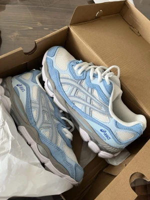 Asics sneakers i vitt och ljusblått - Snygga Asics, helt oanvända i storlek 42. Box medföljer. Passar perfekt till vår/ sommar som är runt hörnet. Pris kan diskuteras vid snabb affär.