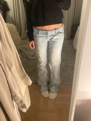 Ljusblå baggy jeans med slitningar - Aldrig använda men köpte de förstora så jag tvättade de så de kan nog var pytte lite mindre men annars hel nya. ❤️jag kommer såklart stryka innan ja skickar för nu är det väldigt skrynkliga❤️Säljer ett par ljusblå baggy jeans med slitna detaljer på benen och klassisk femficksdesign. Jeansen har låg midja och raka ben som ger en avslappnad vibe. Perfekta för dig som gillar en chill och trendig stil.