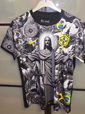 Nike Brasil t-shirt  - Unik svart t-shirt från Nike med Brasil-tema och grafiskt tryck av Kristusstatyn, brasilianska flaggan och CBF-loggan. T-shirten har korta ärmar och färgglada detaljer i gult, grönt och blått. Perfekt för dig som vill sticka ut med en cool och sportig look. Den är helt oanvänd men tvättad. Tveka inte för att ställa frågor! Priset är inget hugget i sten.