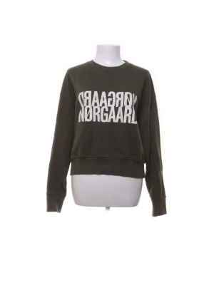 Grön sweatshirt från Nørgaard - Mörkgrön sweatshirt från Nørgaard med vit, stor logotyp framtill. Tröjan har rund halsringning, långa ärmar och ribbade muddar vid ärmslut och nederkant. Perfekt för en avslappnad och cool stil.