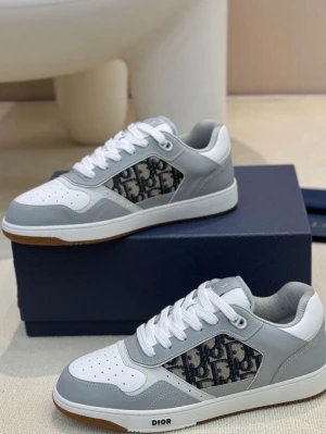 Dior B27 sneakers - Snygga sneakers från Dior i grått och vitt med klassiskt Dior-monogram i textil på sidan. Skorna har snörning, rund tå och platt sula. Materialmix av skinn och textil ger en exklusiv känsla och modern look.