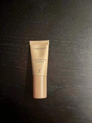 Lumene Eyeshadow Primer 8ml - Lumene Eyeshadow Primer i en beige tub på 8 ml. Primern är vegansk och kommer i en smidig plastförpackning med skruvlock. Perfekt för att få ögonskuggan att sitta längre och ge en jämnare bas. Enkel att applicera och passar alla hudtoner.