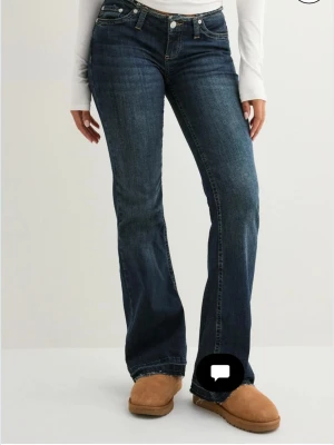 Mörkblå bootcut jeans - Snygga mörkblå jeans med bootcut passform. Jeansen har låg midja och råa kanter längst ner. Har använt max två gånger och inga defekter💕skriv för fler bilder, nypris 699