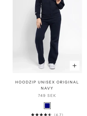 Marinblå zip hoodie unisex - Snygg marinblå zip hoodie från Russemerch i unisexmodell. Hoodien har dragkedja framtill, fickor på sidorna och en klassisk huva. Perfekt för en avslappnad och sportig stil. Tillverkad i mjukt och bekvämt material.