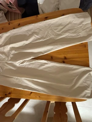 Beiga raka kostymbyxor i bomull direkt från Zara.  - Köpte dem och hann inte returnera. Är lite för stora för mig . Säljer ett par stilrena beiga kostymbyxor i rak passform. Byxorna är tillverkade i mjuk bomull och har en klassisk look som passar till det mesta. Perfekta för dig som vill ha ett par ljusa byxor med enkel och clean stil.