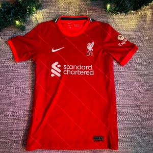 Liverpool Fotbollströja 2021-22 - Liverpool Fotbollströja från säsongen 2021-22, helt ny, köpt från unisport för 600 kr, storlek 147-152! Har du några frågor så är det bara att skriva!😁👍🏼