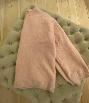 Ljusrosa stickad tröja ARKET - Mysig ljusrosa stickad tröja med rund hals och ribbade muddar vid ärmslut och nederkant. Från ARKET, nypris 999 kr