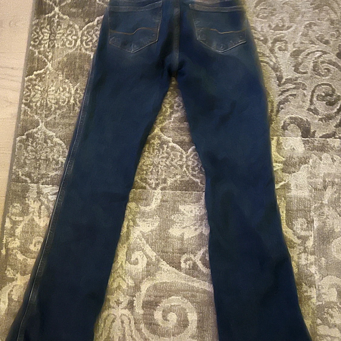 Blå jeans med stora hål vid knäna - 1