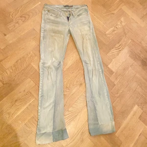 Levis lågmidjade ljusblå bootcut jeans - Ljusblå Levis Demi Curve jeans med låg midja och klassisk femficksdesign. Omsydda till bootcut men inget som syns