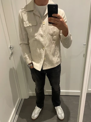Beige vårjacka/overshirt från Mango - Säljer nu en snygg beige vårjacka från Mango. Jackan är i storlek S och tillverkad i linne/bomull. Väldigt stilren och allmänt fin jacka. Säljes för 300kr och kan skickas. 