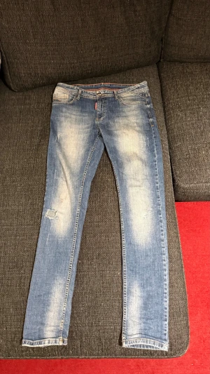 Blå skinny jeans med slitningar - Snygga blå jeans med slim  passform och slitna detaljer på benen. Jeansen har klassisk femficksdesign och ljusa partier framtill för en cool, använd look. Perfekta till sneakers och t-shirt för en avslappnad stil.