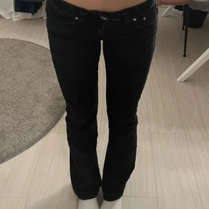 Svarta bootcut jeans från Perfect Jeans - Snygga svarta jeans från Perfect Jeans i storlek 34. Modellen har bootcut-ben och klassisk femficksdesign med silverfärgade nitar och knapp. Jeansen har låg midja och är tillverkade i mjukt denim-material som sitter skönt hela dagen.