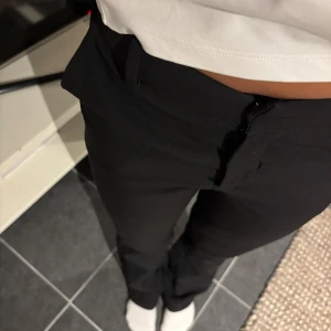 Svarta raka kostymbyxor - Snygga svarta kostymbyxor med rak passform och medelhög midja. Byxorna har bälteshällor och stängs med dragkedja och knapp framtill. De är från bikbok och köpte för några år sedan men är fortfarande i mycket bra skick. Säljer nu pga att de är lite små för mig, men har annars väldigt bra passform och passar dig som är runt 165. Hör av dig för fler bilder! 