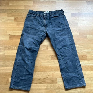 Levi's 505 grå jeans straight fit - Klassiska Levi's 505 jeans i grå tvätt med raka ben och normal passform. Jeansen har fem fickor, knappgylf och tydliga kontrastsömmar. Perfekta för dig som gillar en tidlös och avslappnad stil.