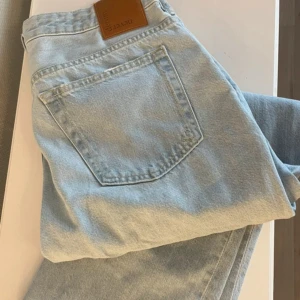 Ljusblå straight jeans från Never Denim - Säljer ett par ljusblå jeans från Never Denim med rak passform och klassisk femficksdesign. Jeansen har låg midja, bälteshällor och dragkedja. Perfekta för dig som gillar en clean och enkel look.