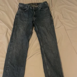 Blå jeans från Karve med rak passform W/29 - Säljer ett par klassiska blå jeans från Karve med rak passform. Jeansen har fem fickor, normal midja och är tillverkade i ett robust denimtyg. Perfekta för dig som gillar en enkel och tidlös stil.