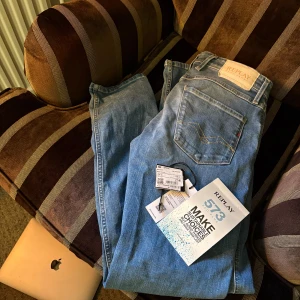 Replay 573 jeans ljusblå straight - Ljusblå jeans från Replay, modell 573, med klassisk femficksdesign och raka ben. Jeansen har Replay-logga på bakfickan och läderpatch i midjan. Materialet är mjukt denim med snygga slitningar och kontrastsömmar.  (HELT NYA) använda en gång. Köpta på MQ har jag för mig men dom var inte riktigt min stil, bara att skicka för fler bilder eller frågor!😁