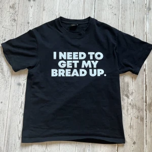 Corteiz tshirt - Svart t-shirt från Corteiz i storlek Small med fet vit text på bröstet: 'I NEED TO GET MY BREAD UP.' och 'TODAY.' på ryggen. Klassisk passform och rund hals. Perfekt statement-plagg för dig som vill sticka ut.