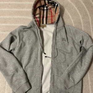 Burberry zip hoodie - Burberry zip hoodie använd ett tag men skicket är 9/10. Allt är bra och inga defekter. Storlek M hör av er vid intresse!
