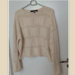 Beige stickad tröja från Vero Moda, M - Superfin beige stickad tröja från Vero Moda med hålmönster i fyrkantiga rutor. Tröjan har rund halsringning och långa ärmar, perfekt för lager-på-lager. Mjuk och luftig känsla, passar snyggt till jeans eller kjol.