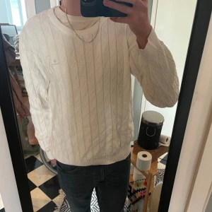 Vit stickad tröja från GANT 3XL - Den passar mig bra som brukar ha L/XL så liten i storleken. Vit stickad tröja från GANT i storlek 3XL. Tröjan har ett snyggt geometriskt mönster, rund halsringning och ribbade muddar. Perfekt för dig som gillar klassisk och clean stil med en twist.