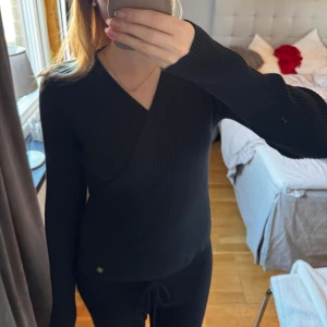 Svart omlottstickad tröja - Säljer en helt ny omlott tröja från Pernilla Wahlgrens kollektion hos Ullared. Den är aldrig använd (utan prislapp) så därför i nytt skick. Den är super mjuk och är både fin att ha hemma eller att klä upp. Hör gärna av dig vid frågor❤️