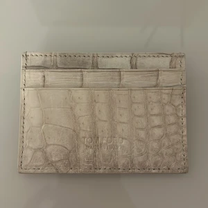 plånbok Himalayan från Tom Ford - plånbok från Tom Ford med krokodilskin effect. Slimmad design med flera kortfack och diskret logga framtill. Perfekt för dig som gillar stilrena accessoarer med lyxig känsla. Fraktas inom 24 timmar efter köp🚛📦