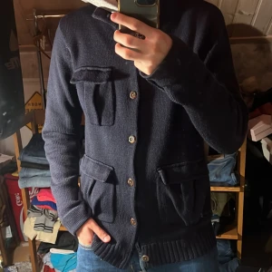 Stickad A.P.C Cardigan - Säljer denna riktigt snygga cardigan från A.P.C. Den är i storlek L och är i 50% merinoull, 50% acrylic. Cardiganen är i bra skick utan defekter. Bara att skriva över frågor och funderingar.