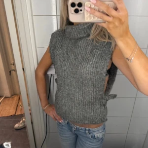 stickad polotröja  - fin tröja! öppen på sidorna med rosett till knytning