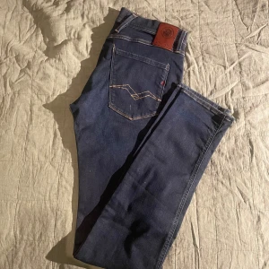 Replay Hyperflex Anbass jeans blå - Säljer ett par mörkblå Replay Hyperflex Anbass jeans med klassisk femficksdesign och snygga kontrastsömmar. Jeansen är stretchiga och har en rak passform med normal midja. Perfekta för dig som vill ha både stil och komfort. Nypris: 1300. Mitt pris: 550! Hör av er vid funderingar!