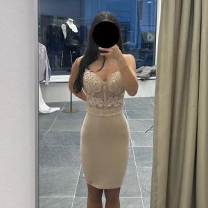 Beige spetsklänning med smala axelband - Supersnygg beige kortklänning med smala axelband och figurnära passform. Överdelen har vacker spets och broderade detaljer, medan kjolen är enkel och slät.                                             Finns i alla storlekar XS-XL                                      Pris går att diskutera. 